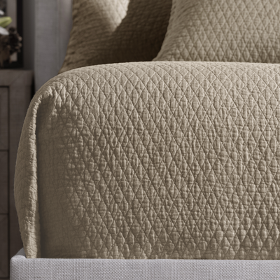 Close-up of a textured beige fabric surface on a piece of furniture.